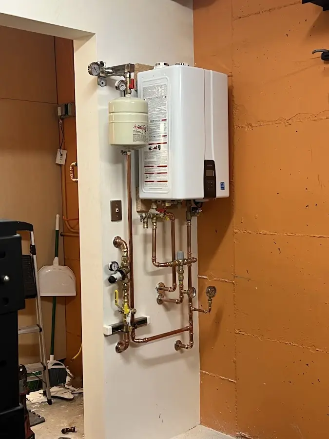 Plumbing technician inspecting water heater connections in Niles